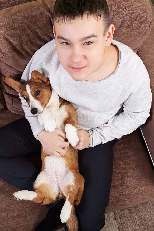 Un niño con un perro está tumbado en el sofá fotos de archivo