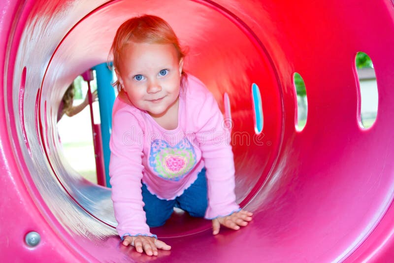 Un niño feliz que se arrastra a través de un túnel del juego.