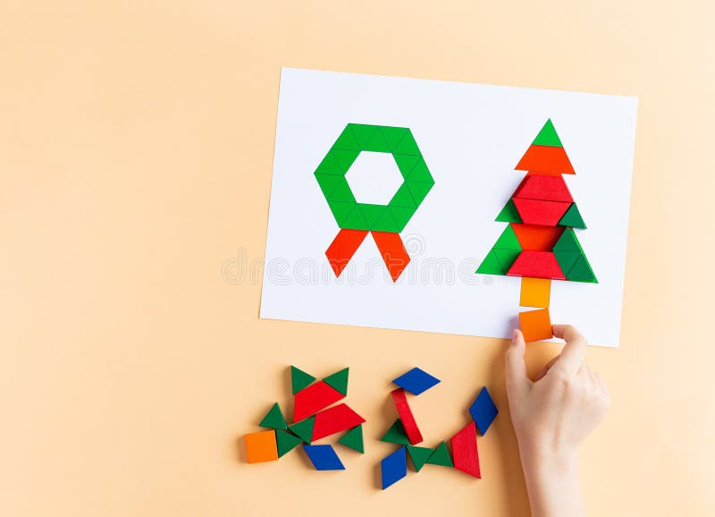 Un niño juega con bloques de colores. madera forma navidad símbolos navidad árbol y corona fotografía de archivo libre de regalías