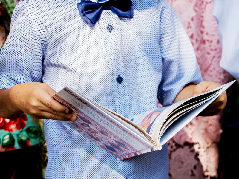 Un niño pequeño sostiene en sus manos un libro revelado Lectura inter fotografía de archivo libre de regalías Un niño pequeño sostiene en sus manos un libro revelado Lectura inter fotografía de archivo libre de regalías