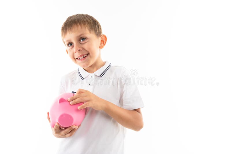 Un niño rubio sostiene una caja de cerdo y se regocija, foto aislada en fondo blanco imagenes de archivo Un niño rubio sostiene una caja de cerdo y se regocija, foto aislada en fondo blanco imagenes de archivo