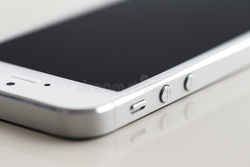 Un nuovo smartphone bianco su un fondo riflettente bianco fotografia stock libera da diritti