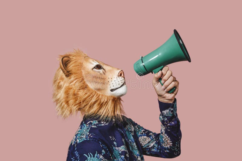 Un om care poartă o mască de leu vorbește într-un megafon stock image