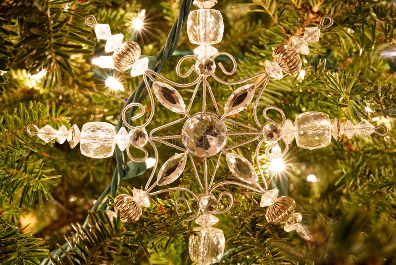 Un ornamento de la Navidad del copo de nieve en un árbol de la piel foto de archivo libre de regalías Un ornamento de la Navidad del copo de nieve en un árbol de la piel foto de archivo libre de regalías