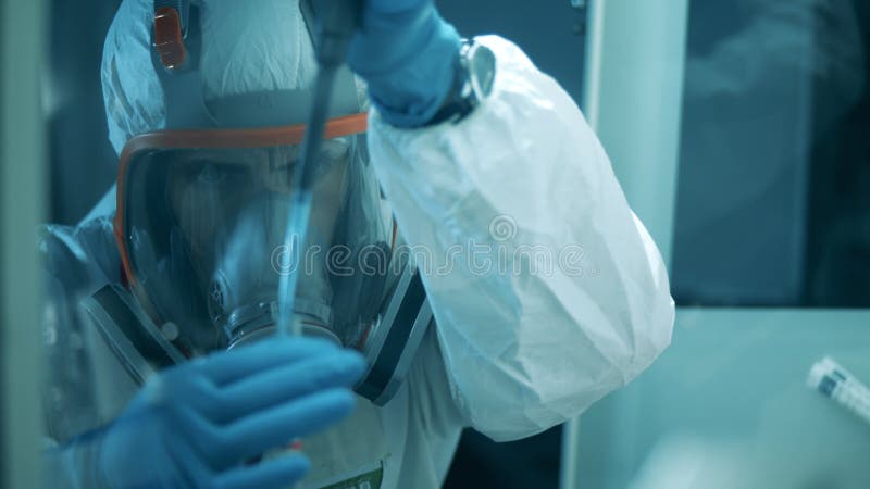Un ouvrier de laboratoire dans une combinaison de protection effectue une recherche chimique. covid19 coronavirus concept.