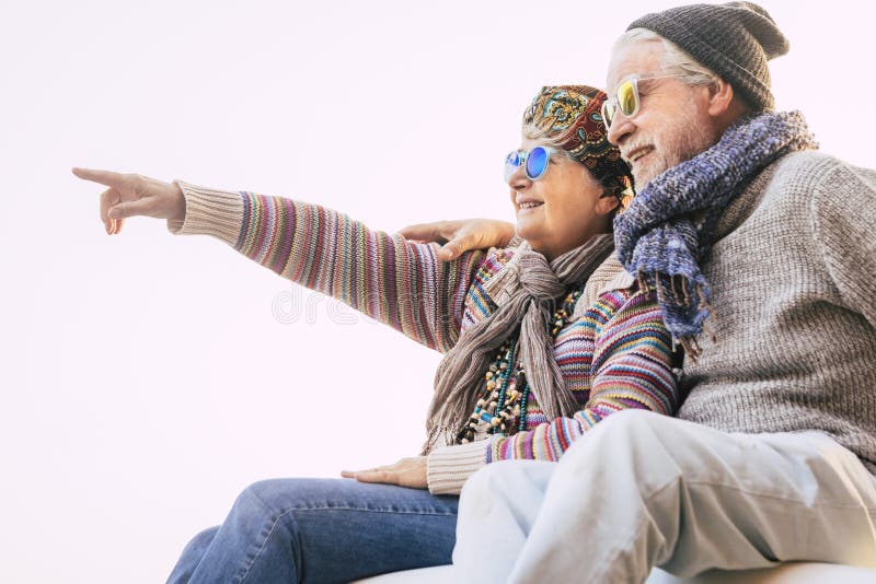 Un paio di anziani abbracciati con vestiti invernali che sorridono e mostrano persone mature e felici insieme all'esterno fotografia stock libera da diritti Un paio di anziani abbracciati con vestiti invernali che sorridono e mostrano persone mature e felici insieme all'esterno fotografia stock libera da diritti