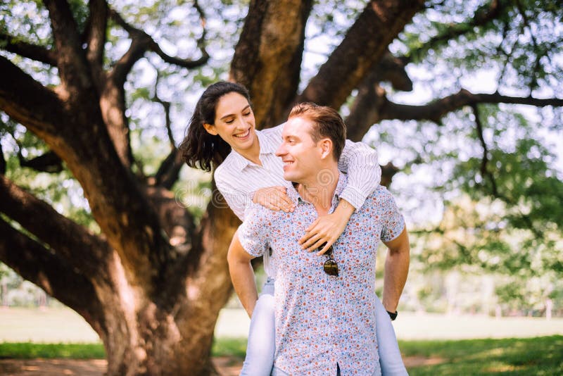 Un paio di giovani innamorati che viaggiano a Park, romantici e si divertono nel momento della felicità, felici e sorridenti, mag immagine stock libera da diritti Un paio di giovani innamorati che viaggiano a Park, romantici e si divertono nel momento della felicità, felici e sorridenti, mag immagine stock libera da diritti