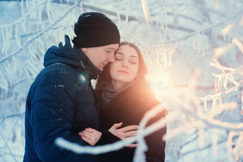 Un par cariñoso en un paseo del invierno Historia de amor de la nieve, magia del invierno Hombre y mujer en la calle escarchada E imagen de archivo Un par cariñoso en un paseo del invierno Historia de amor de la nieve, magia del invierno Hombre y mujer en la calle escarchada E imagen de archivo