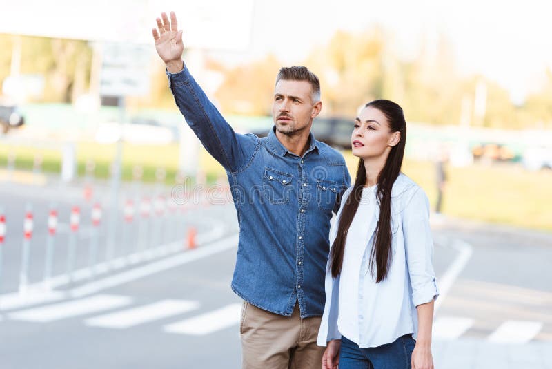 Un par de personas adultas que llaman el taxi foto de archivo Un par de personas adultas que llaman el taxi foto de archivo