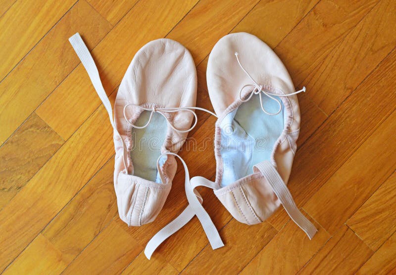 Un par de zapatos de ballet rosados en el suelo del entarimado foto de archivo libre de regalías Un par de zapatos de ballet rosados en el suelo del entarimado foto de archivo libre de regalías