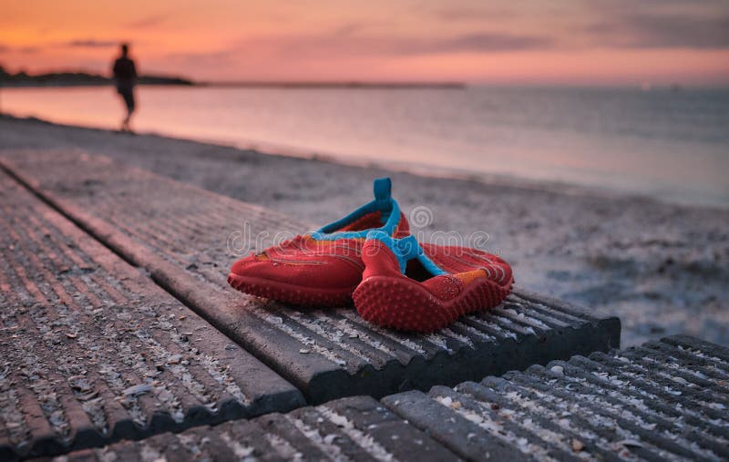 Un De Zapatos Rojos Para Niños Dejados En Playa Foto de - Imagen de aislado, zapato: 181801802
