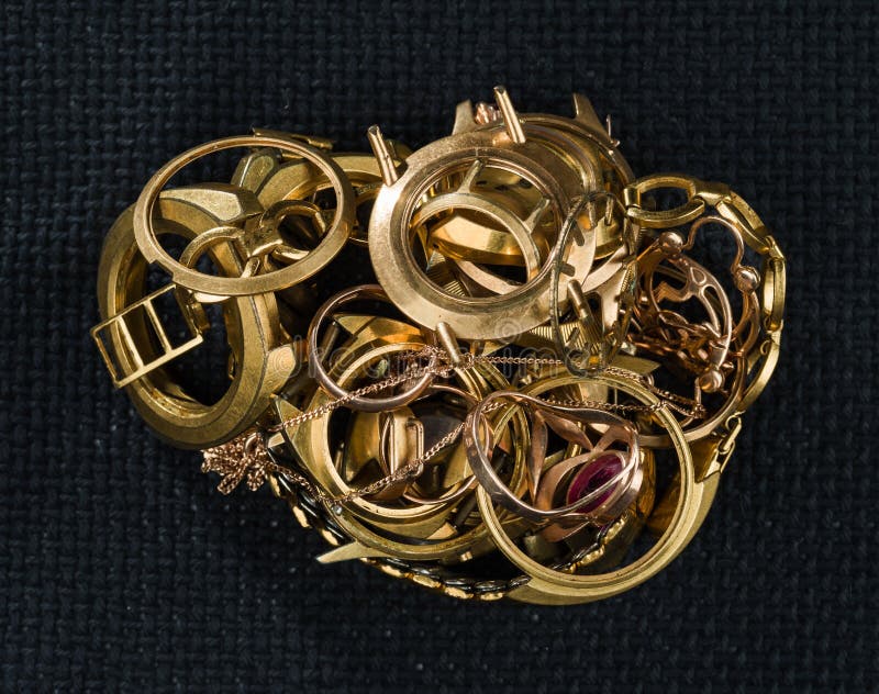 Un pedazo del oro Joyería vieja y quebrada, relojes del oro y dorado contra un fondo de una textura oscura imagen de archivo Un pedazo del oro Joyería vieja y quebrada, relojes del oro y dorado contra un fondo de una textura oscura imagen de archivo
