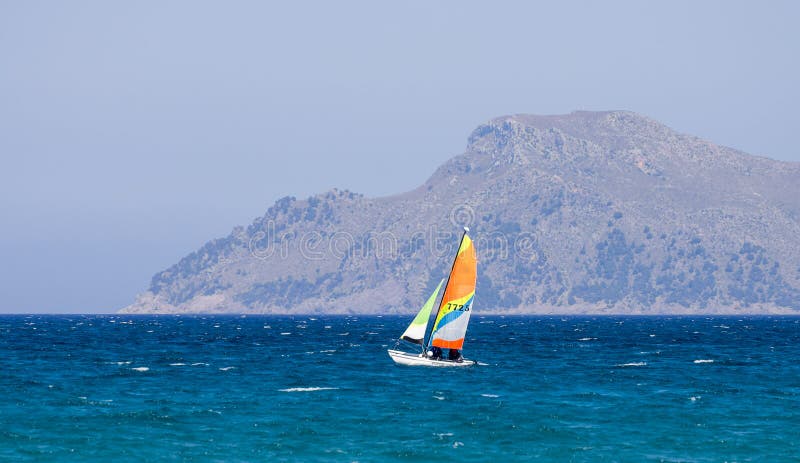Un pequeño barco de navegación en la bahía de Alcudia cerca puede ciudad de Picafort, Majorca imagen de archivo Un pequeño barco de navegación en la bahía de Alcudia cerca puede ciudad de Picafort, Majorca imagen de archivo