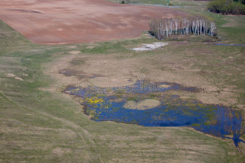 Un pequeño lago al borde de un campo arado imagen de archivo Un pequeño lago al borde de un campo arado imagen de archivo