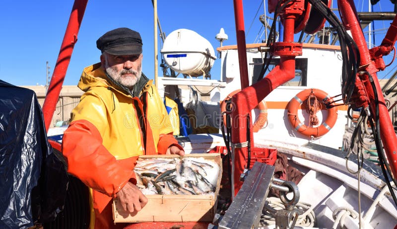 Un pescador con una zona acotada de pesca dentro de un barco de pesca imágenes de archivo libres de regalías Un pescador con una zona acotada de pesca dentro de un barco de pesca imágenes de archivo libres de regalías