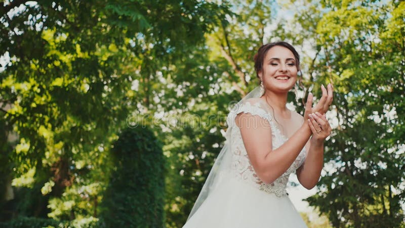 Un petit chaton mignon se repose sur l'herbe au bord de la robe de mariage de la jeune mariée contact Le moment du