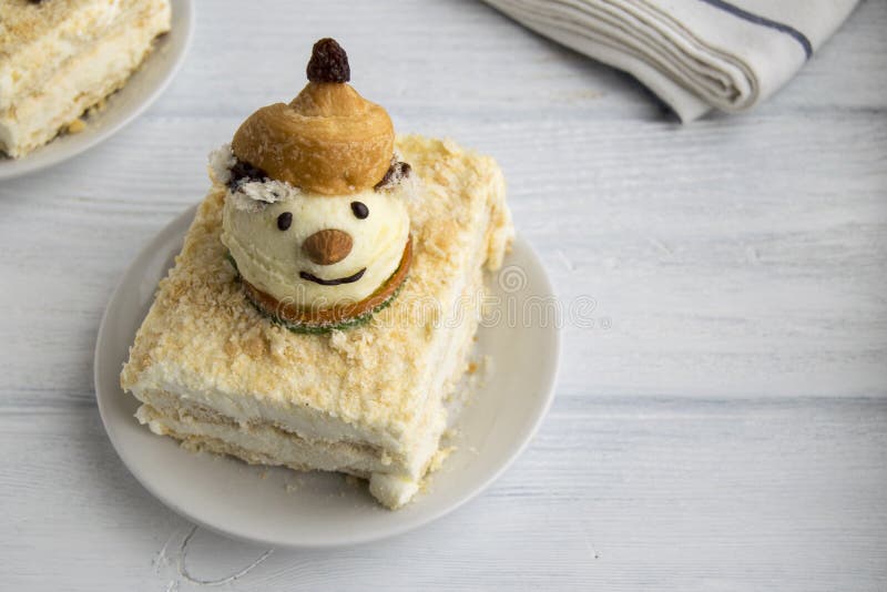 A piece of cake is on a plate. Napoleon cake consists of biscite and ice cream. The cake is decorated with snowman  ice cream. Creative  dessert. A piece of cake is on a plate. Napoleon cake consists of biscite and ice cream. The cake is decorated with snowman  ice cream. Creative  dessert