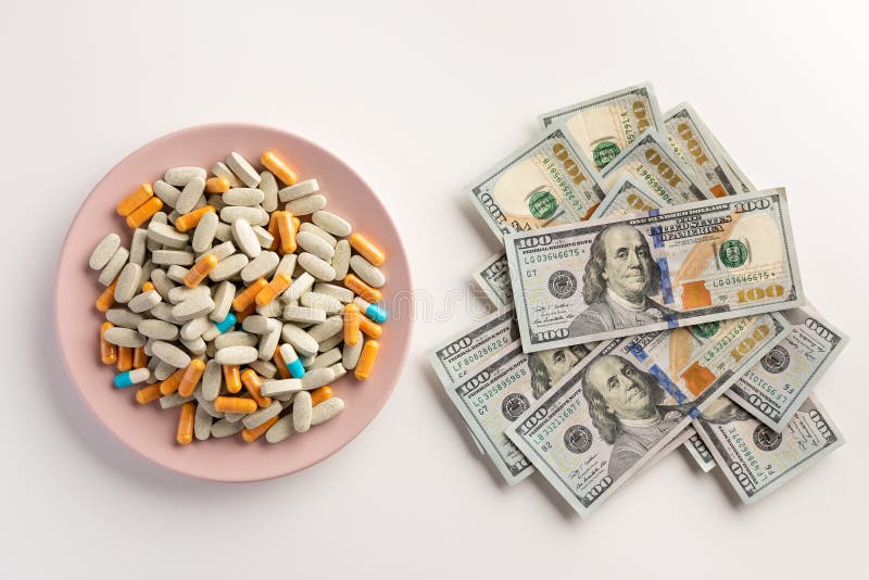 Un piatto con le pillole ed il mucchio dei dollari isolati su bianco immagini stock Un piatto con le pillole ed il mucchio dei dollari isolati su bianco immagini stock