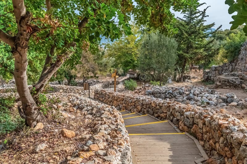 Un pintoresco camino en el castillo de Alanya, Turquía, rodeado de vegetación y rodeado de muros de piedra rústicos. El camino lle imagen de archivo libre de regalías