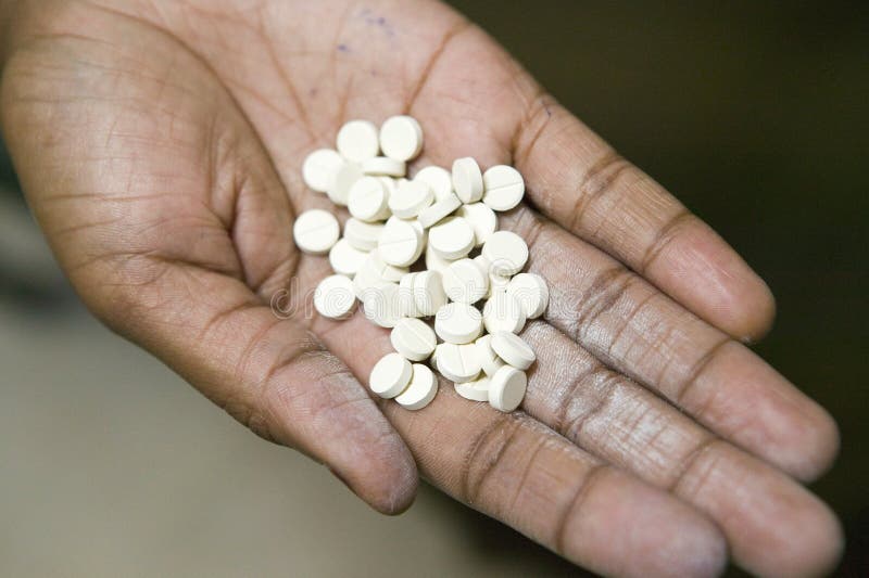 Un plan rapproché d'une main tient des pilules de SIDA chez le programme de rééducation de Pepo La Tumaini Jangwani, de la Commun photo libre de droits Un plan rapproché d'une main tient des pilules de SIDA chez le programme de rééducation de Pepo La Tumaini Jangwani, de la Commun photo libre de droits
