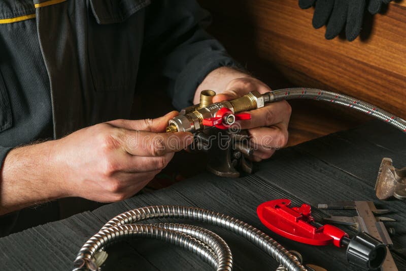 Un Plombier Relie Les Raccords En Laiton à Un Robinet D'eau Gros Plan D'une  Main De Maître Tout En Travaillant Dans Un Atelier