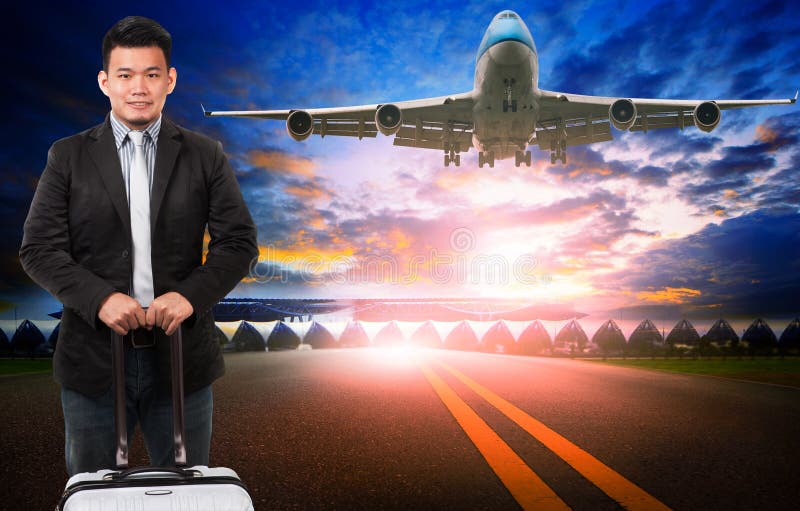 Un plus jeune homme asiatique et un bagage de déplacement se tenant contre le passeng photos stock Un plus jeune homme asiatique et un bagage de déplacement se tenant contre le passeng photos stock