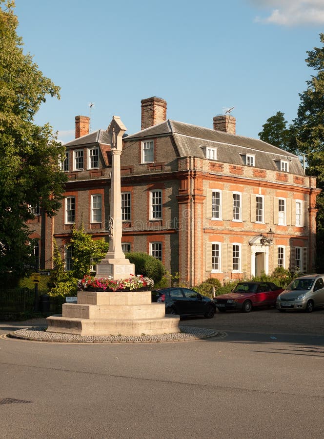 Un point de repère de mémorial de guerre devant une maison majestueuse dans l'esprit de dedham photo stock Un point de repère de mémorial de guerre devant une maison majestueuse dans l'esprit de dedham photo stock