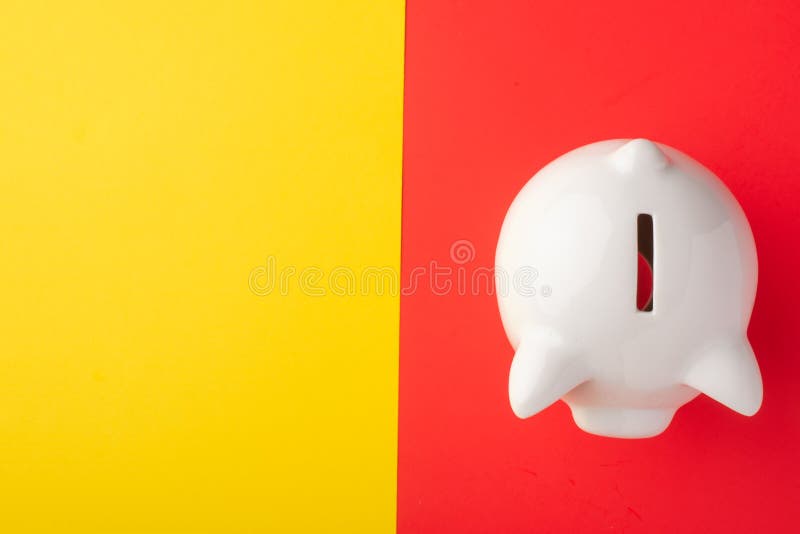 Un porcellino salvadanaio su un fondo rosso-giallo Concetto di risparmio dei soldi saving Vista da sopra fotografia stock libera da diritti Un porcellino salvadanaio su un fondo rosso-giallo Concetto di risparmio dei soldi saving Vista da sopra fotografia stock libera da diritti