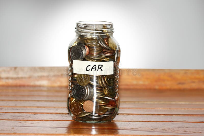A glass jar full of coins to represents new car concept- with masking tape and donation written on it. A glass jar full of coins to represents new car concept- with masking tape and donation written on it.