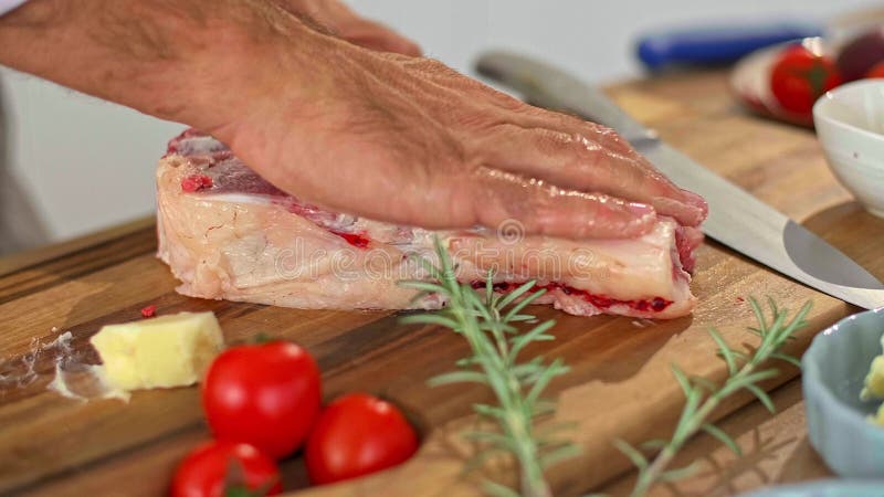 Un primer plano de un chef frotando mantequilla en un trozo de carne almacen de metraje de vídeo