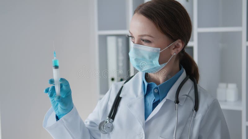 Un profesionist dedicat în domeniul asistenței medicale care poartă o mască față în timp ce revizuiește meticulos informațiile des stock footage