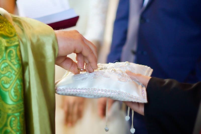 Un prêtre chrétien tient dans des ses mains un anneau de mariage photographie stock Un prêtre chrétien tient dans des ses mains un anneau de mariage photographie stock