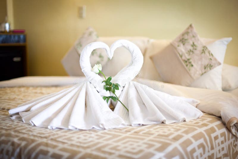 Un punto di vista di due cigni bianchi degli asciugamani sul lenzuolo in hotel fotografia stock libera da diritti Un punto di vista di due cigni bianchi degli asciugamani sul lenzuolo in hotel fotografia stock libera da diritti