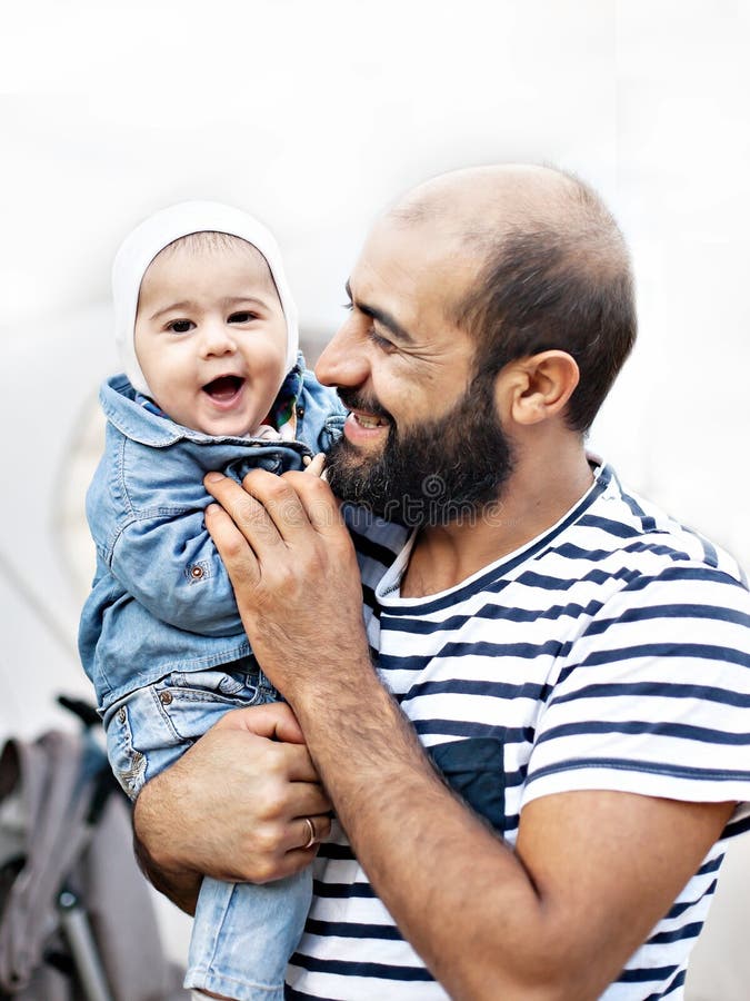 Un père affectueux tient un enfant dans des ses bras Photo émotive image stock Un père affectueux tient un enfant dans des ses bras Photo émotive image stock