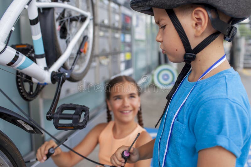 Un père aide son enfant à réparer une bicyclette mettant en vedette le travail d'équipe et l'apprentissage manuel photographie stock libre de droits
