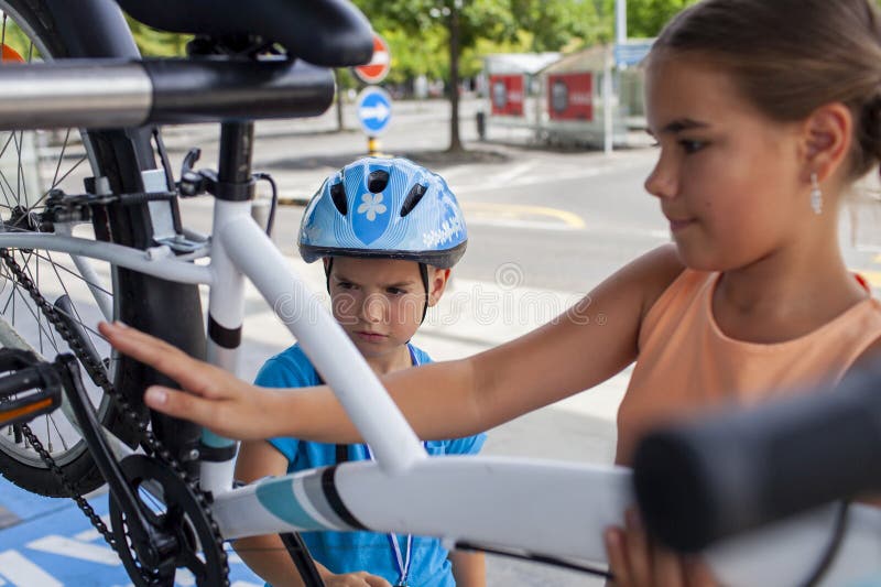 Un père aide son enfant à réparer une bicyclette mettant en vedette le travail d'équipe et l'apprentissage manuel photographie stock libre de droits