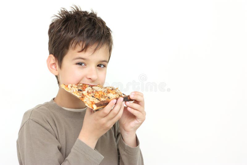 Un ragazzo che mangia pizza fotografia stock Un ragazzo che mangia pizza fotografia stock