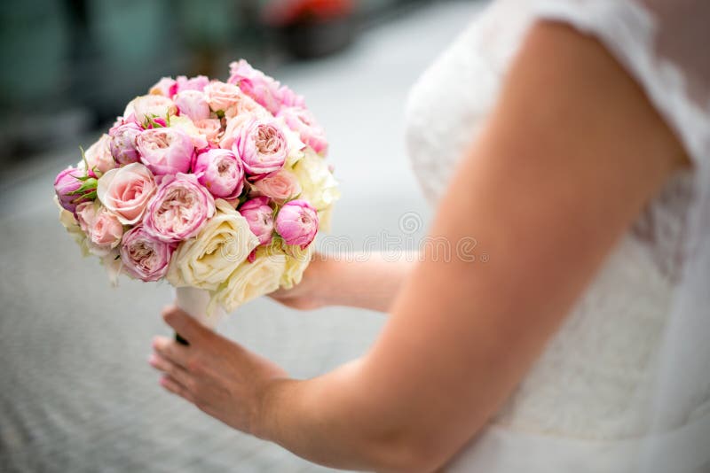 Un ramo de la boda de rosas y de peonías en las manos de la novia Primer En un fondo borroso fotografía de archivo libre de regalías Un ramo de la boda de rosas y de peonías en las manos de la novia Primer En un fondo borroso fotografía de archivo libre de regalías