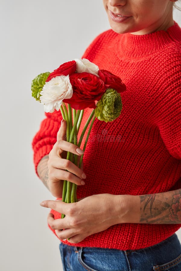 Un ramo fresco de ranúnculo de las flores en las manos de una mujer en un fondo gris tarjeta fotografía de archivo libre de regalías Un ramo fresco de ranúnculo de las flores en las manos de una mujer en un fondo gris tarjeta fotografía de archivo libre de regalías