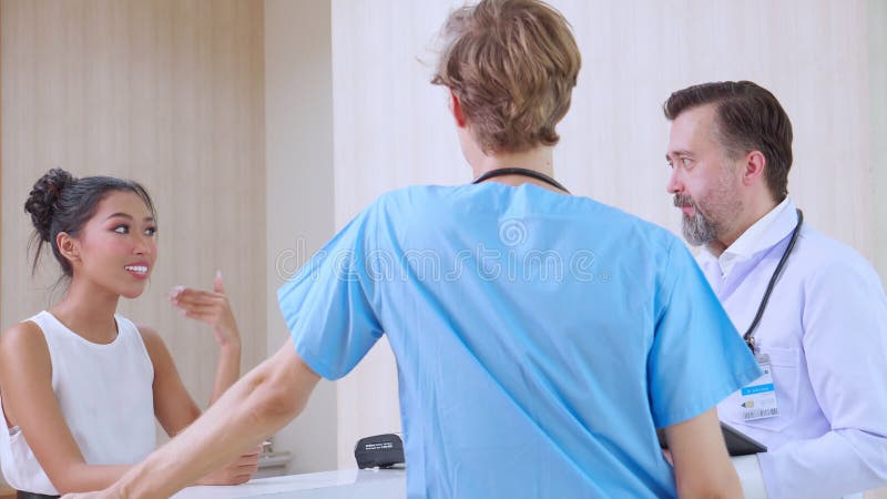 Un receptionist felice che discute di salute con un medico attento nella diversità e nell'etnia cliniche o ospedaliere.