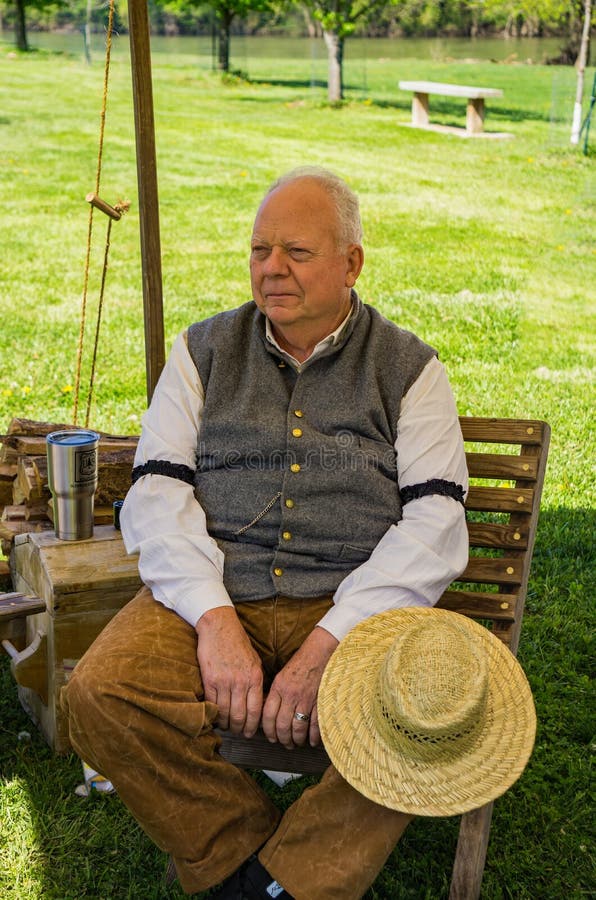 Un Reenactor masculino mayor que se relaja en el acampamento confederado fotos de archivo Un Reenactor masculino mayor que se relaja en el acampamento confederado fotos de archivo