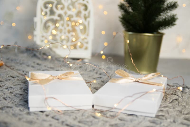 Un regalo di due Natali in scatola bianca con il nastro leggero su fondo leggero Insegna della composizione in festa del nuovo an fotografia stock Un regalo di due Natali in scatola bianca con il nastro leggero su fondo leggero Insegna della composizione in festa del nuovo an fotografia stock