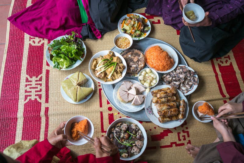 Un repas vietnamien traditionnel pour des vacances lunaires de Tet de nouvelle année au printemps, placé sur le nouveau tapis fle image stock Un repas vietnamien traditionnel pour des vacances lunaires de Tet de nouvelle année au printemps, placé sur le nouveau tapis fle image stock