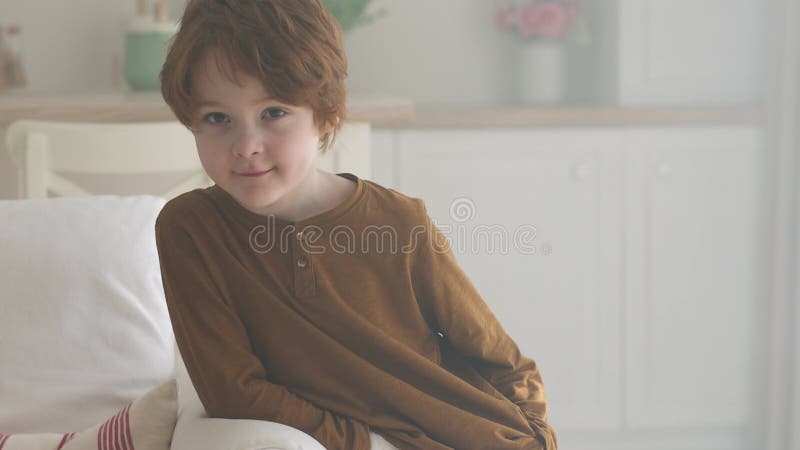 Un retrato de niño preescolar pelirrojo en casa