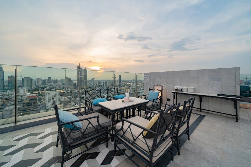 Un ristorante o una terrazza di bar con tavola sul tetto dell'hotel, un edificio ad alta ascesa con vista in città immagini stock libere da diritti