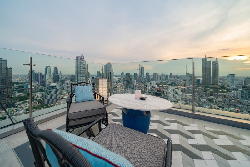Un ristorante o una terrazza di bar con tavola sul tetto dell'hotel, un edificio ad alta ascesa con vista in città immagine stock libera da diritti