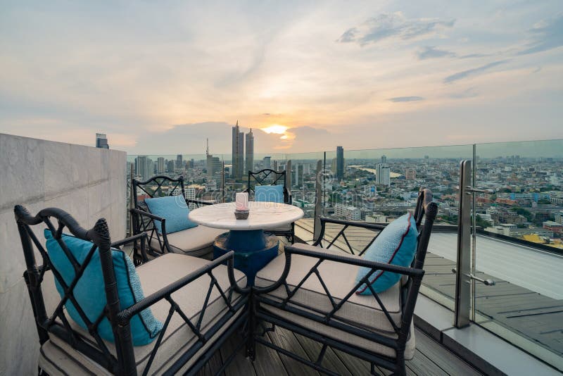 Un ristorante o una terrazza di bar con tavola sul tetto dell'hotel, un edificio ad alta ascesa con vista in città. Sky bar, un ristorante o una terrazza locale con tavola da pranzo sul tetto dell'hotel, un edificio ad alta ascesa con vista cittadina nel centro di Bangkok skyline, città urbana, Thailandia