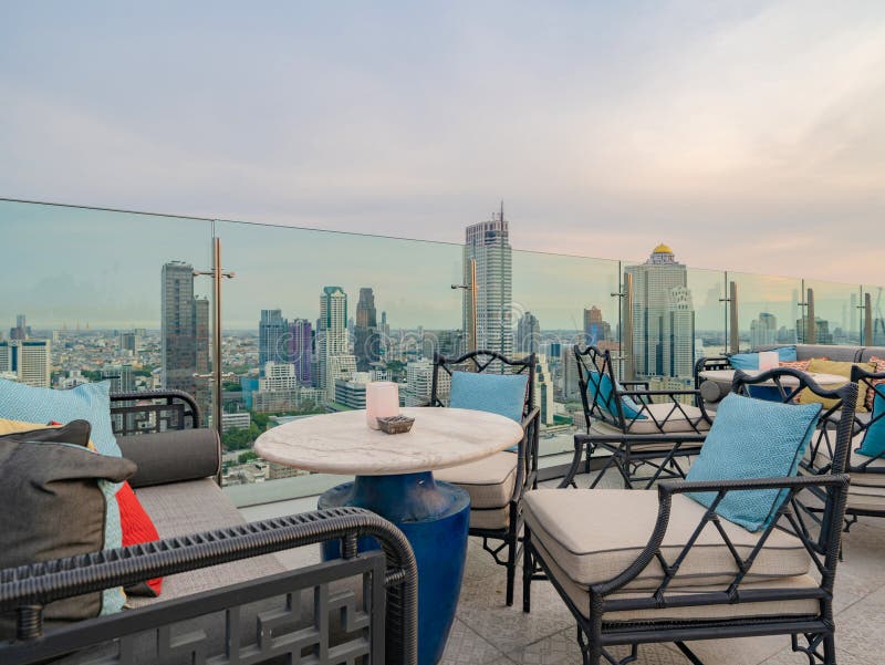 Un ristorante o una terrazza di bar con tavola sul tetto dell'hotel, un edificio ad alta ascesa con vista in città fotografie stock libere da diritti