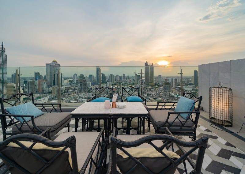 Un ristorante o una terrazza di bar con tavola sul tetto dell'hotel, un edificio ad alta ascesa con vista in città fotografia stock
