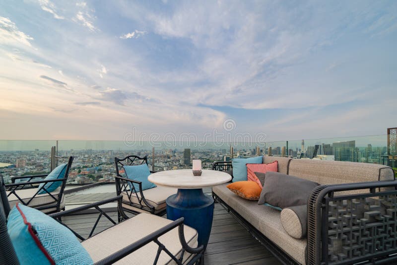 Un ristorante o una terrazza di bar con tavola sul tetto dell'hotel, un edificio ad alta ascesa con vista in città immagini stock libere da diritti